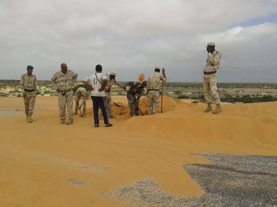 عناصر كتيبة عسكرية يقومون بإزاحة الألسنة الرملية